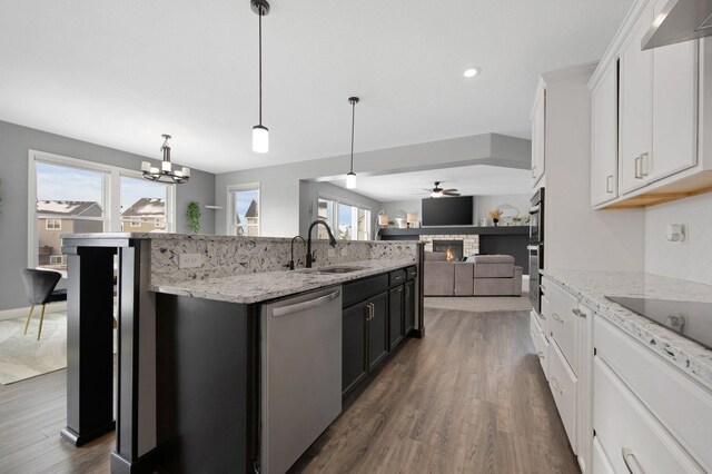 5204 Porchlight, Woodbury, MN 55129 - kitchen featuring a wealth of natural light, a center island with sink, a sink, open floor plan, and appliances with stainless steel finishes