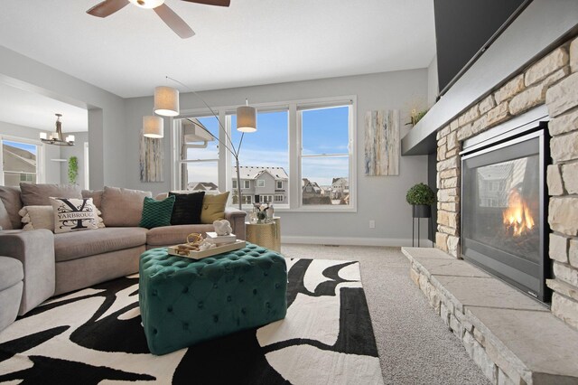 5204 Porchlight, Woodbury, MN 55129 - living area featuring a stone fireplace, ceiling fan with notable chandelier, baseboards, and carpet floors