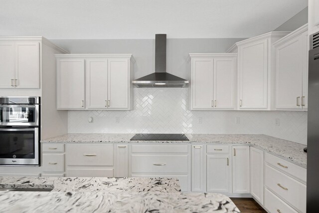 5204 Porchlight, Woodbury, MN 55129 - kitchen with stainless steel double oven, black electric cooktop, white cabinets, and wall chimney range hood