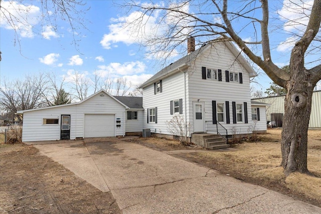 traditional-style home with cooling unit, driveway, an attached garage, and a chimney