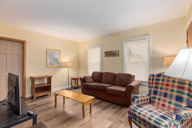 living area with baseboards and light wood finished floors