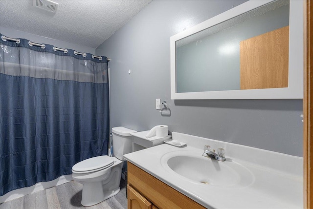bathroom featuring vanity, toilet, a textured ceiling, visible vents, and curtained shower