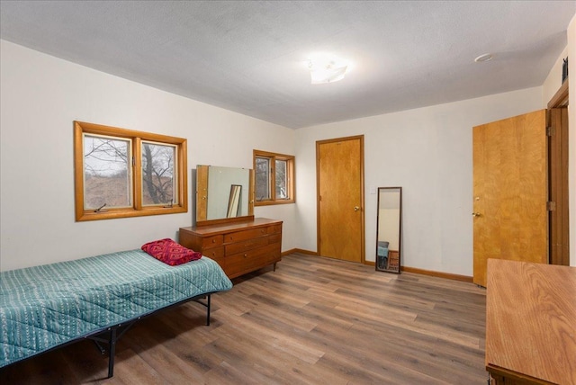 bedroom featuring baseboards and wood finished floors