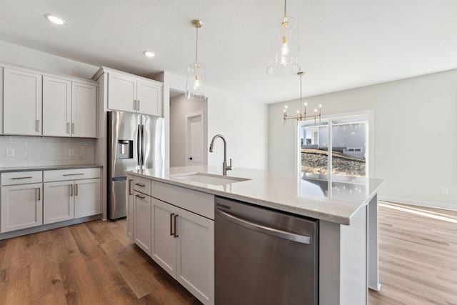 10071 Arrowwood Trl, Woodbury, MN 55129 - kitchen with stainless steel appliances, light wood finished floors, tasteful backsplash, a chandelier, and recessed lighting