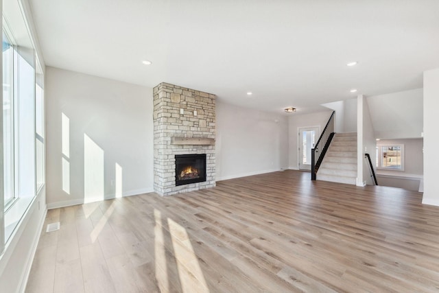 10071 Arrowwood Trl, Woodbury, MN 55129 - unfurnished living room with light wood-style floors, a fireplace, stairs, and recessed lighting