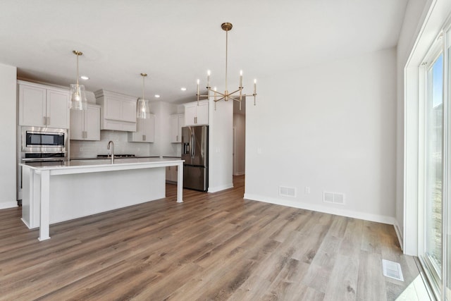 10071 Arrowwood Trl, Woodbury, MN 55129 - kitchen featuring appliances with stainless steel finishes, plenty of natural light, recessed lighting, decorative backsplash, and light wood-style flooring