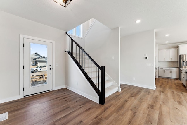 10071 Arrowwood Trl, Woodbury, MN 55129 - stairway with wood finished floors and recessed lighting