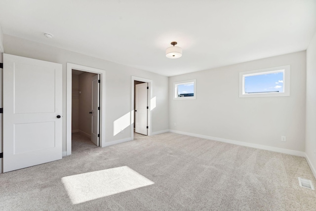 10071 Arrowwood Trl, Woodbury, MN 55129 - unfurnished bedroom with light colored carpet and a walk in closet
