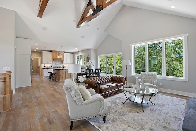 16999 Dakota St NW, Andover, MN 55304 - living area featuring beamed ceiling, baseboards, high vaulted ceiling, and light wood finished floors