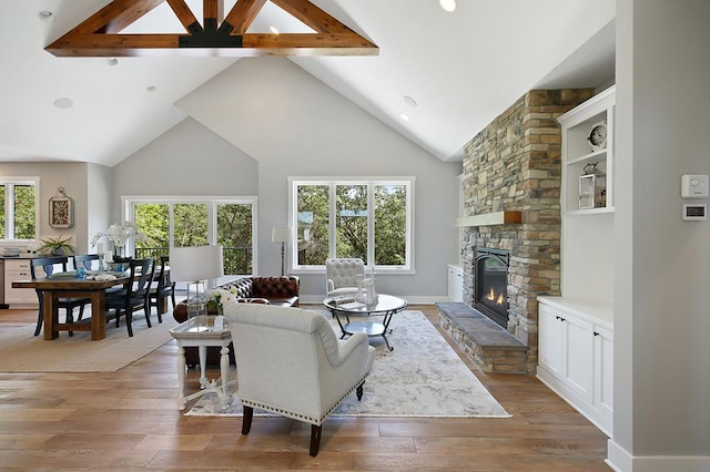 16999 Dakota St NW, Andover, MN 55304 - living area with light wood-type flooring, beam ceiling, high vaulted ceiling, and a stone fireplace
