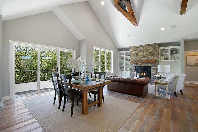 16999 Dakota St NW, Andover, MN 55304 - dining area featuring built in features, baseboards, high vaulted ceiling, a fireplace, and wood-type flooring