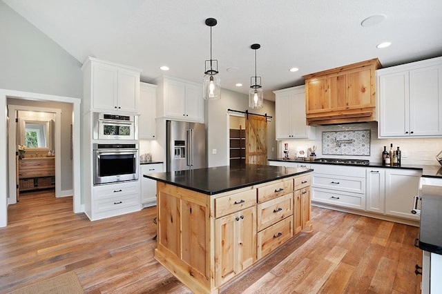 16999 Dakota St NW, Andover, MN 55304 - kitchen featuring a barn door, light wood-style flooring, dark countertops, and appliances with stainless steel finishes