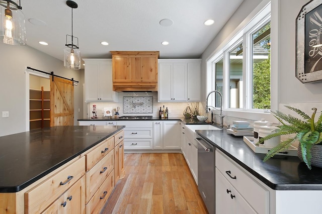 16999 Dakota St NW, Andover, MN 55304 - kitchen featuring dark countertops, light wood-style flooring, stainless steel appliances, and a barn door