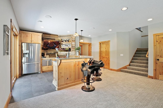 16999 Dakota St NW, Andover, MN 55304 - kitchen featuring stainless steel fridge with ice dispenser, light brown cabinetry, a breakfast bar, recessed lighting, and a textured ceiling