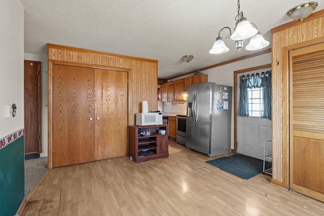 27928 Verdin St NW, Isanti, MN 55040 - kitchen featuring stainless steel appliances, crown molding, light wood-style floors, and a chandelier