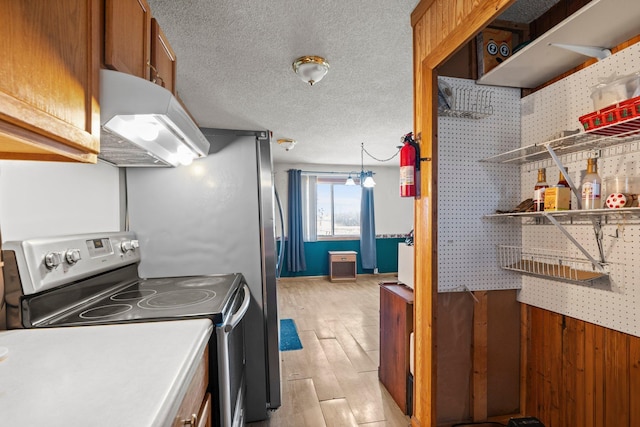 27928 Verdin St NW, Isanti, MN 55040 - kitchen with under cabinet range hood, a textured ceiling, electric stove, light wood finished floors, and brown cabinetry