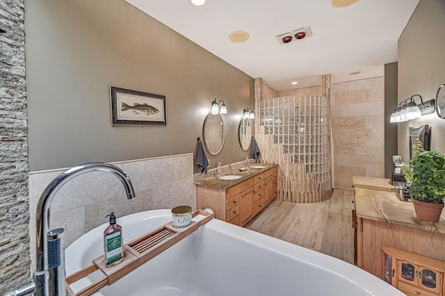 10069 Stacy Trl, Chisago City, MN 55013 - bathroom with a tub to relax in, wood finished floors, and vanity