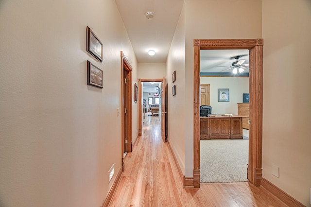 10069 Stacy Trl, Chisago City, MN 55013 - hallway with light wood-style flooring, a desk, and baseboards
