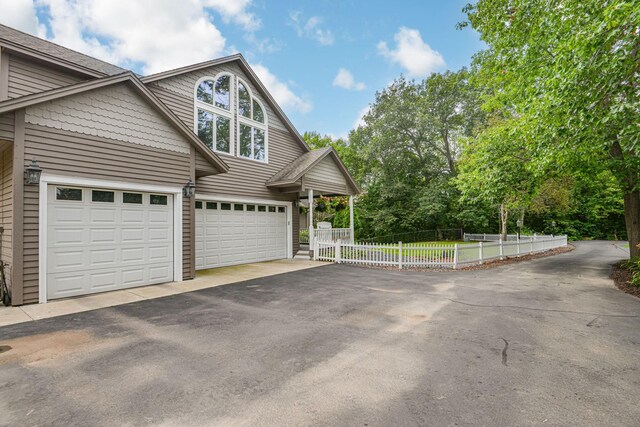 10069 Stacy Trl, Chisago City, MN 55013 - view of front of house featuring asphalt driveway, fence, and a garage