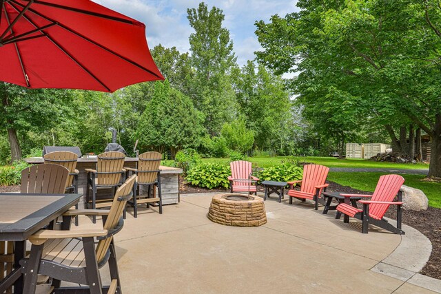 10069 Stacy Trl, Chisago City, MN 55013 - view of patio with an outdoor fire pit, outdoor dining space, and view of scattered trees