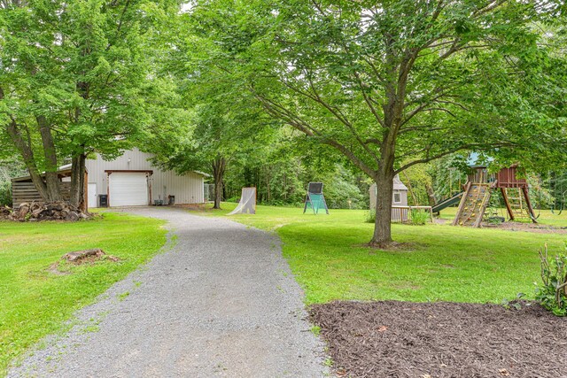 10069 Stacy Trl, Chisago City, MN 55013 - view of grassy yard with an outbuilding, gravel driveway, a playground, and a detached garage