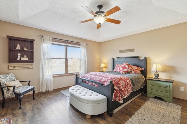 bedroom featuring dark wood finished floors, a textured ceiling, and baseboards