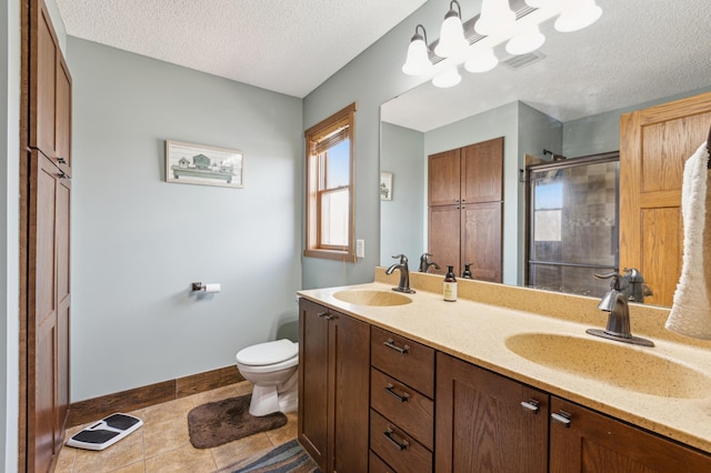 full bath featuring a sink, toilet, a shower stall, and a textured ceiling