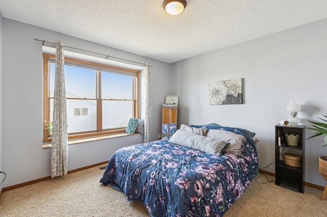 carpeted bedroom with a textured ceiling and baseboards