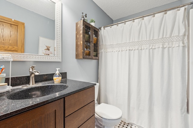 bathroom with toilet, curtained shower, a textured ceiling, and vanity