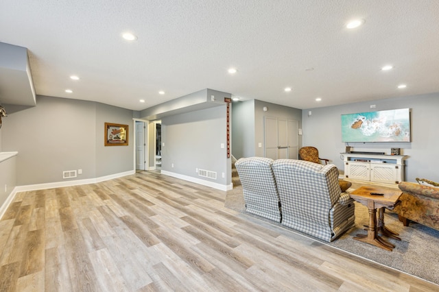 living room featuring recessed lighting, visible vents, baseboards, and light wood-style floors