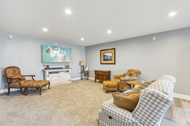 living area featuring recessed lighting, baseboards, a textured ceiling, and carpet flooring