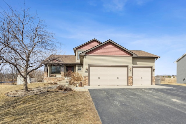craftsman inspired home with stone siding, an attached garage, and driveway