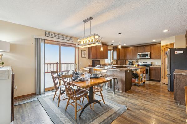 dining space with recessed lighting, wood finished floors, baseboards, and a textured ceiling