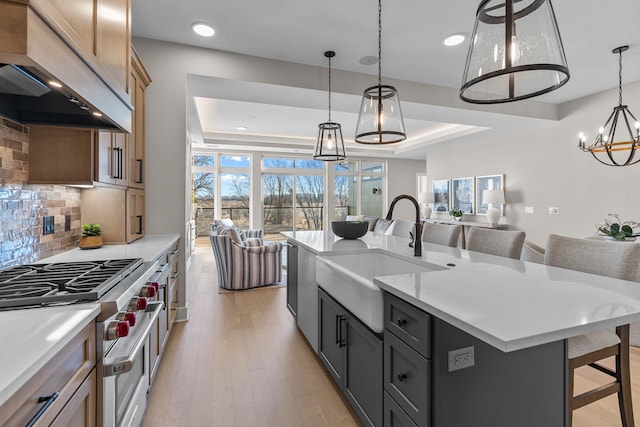 1 Hill Farm Rd Unit 210, North Oaks, MN 55127 - kitchen featuring tasteful backsplash, a sink, a tray ceiling, an inviting chandelier, and custom exhaust hood