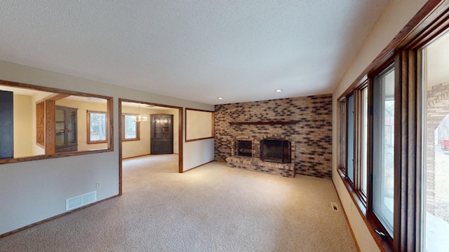 2342 75th Ave, Princeton, MN 55371 - unfurnished living room with healthy amount of natural light, light carpet, a brick fireplace, a textured ceiling, and a chandelier