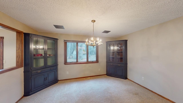 2342 75th Ave, Princeton, MN 55371 - unfurnished dining area featuring a chandelier, light colored carpet, baseboards, and a textured ceiling