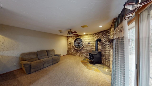 2342 75th Ave, Princeton, MN 55371 - carpeted living room with a wood stove, brick wall, and ceiling fan