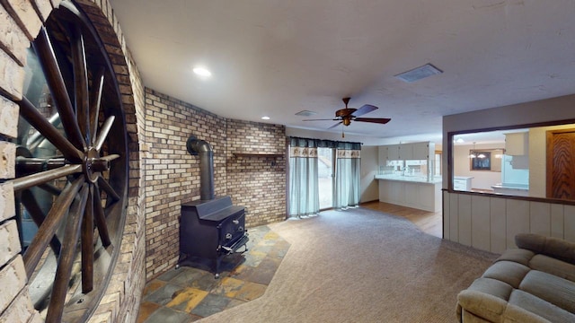 2342 75th Ave, Princeton, MN 55371 - unfurnished living room featuring brick wall, ceiling fan, a wood stove, and recessed lighting