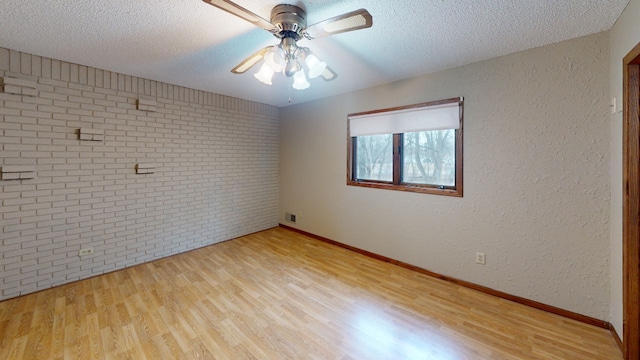 2342 75th Ave, Princeton, MN 55371 - empty room featuring wood finished floors, ceiling fan, a textured ceiling, baseboards, and brick wall