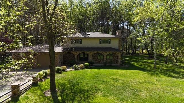 2342 75th Ave, Princeton, MN 55371 - traditional-style home featuring covered porch, driveway, a front yard, stone siding, and a chimney
