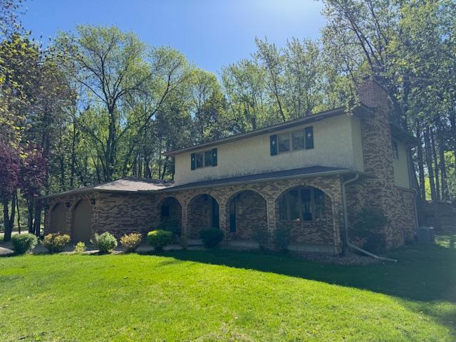 2342 75th Ave, Princeton, MN 55371 - view of front facade featuring stucco siding, a front yard, a chimney, and stone siding
