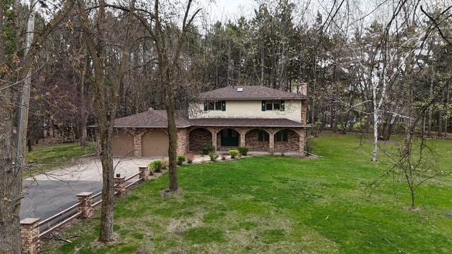 2342 75th Ave, Princeton, MN 55371 - traditional-style house with driveway, a front lawn, a chimney, covered porch, and a garage