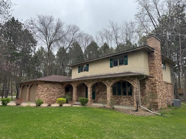 2342 75th Ave, Princeton, MN 55371 - view of front of house with stucco siding, a chimney, a front lawn, and a porch