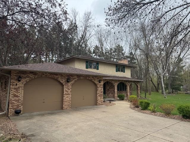 2342 75th Ave, Princeton, MN 55371 - traditional-style home featuring an attached garage, concrete driveway, a chimney, a front yard, and covered porch