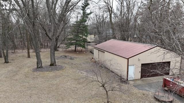 2342 75th Ave, Princeton, MN 55371 - exterior space featuring an outdoor structure, driveway, metal roof, and a detached garage