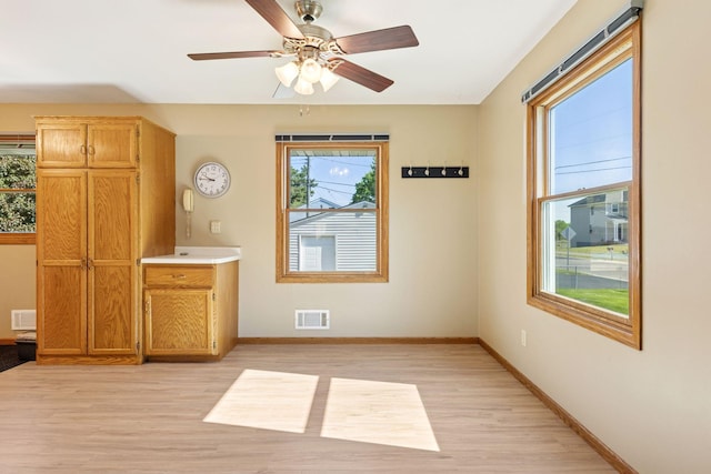 9904 95th Ave N, Maple Grove, MN 55369 - unfurnished dining area with healthy amount of natural light, light wood-type flooring, baseboards, and a ceiling fan