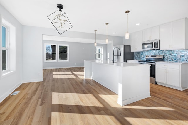 1903 Thomas Ave N, Minneapolis, MN 55411 - kitchen with plenty of natural light, light countertops, white cabinetry, and appliances with stainless steel finishes