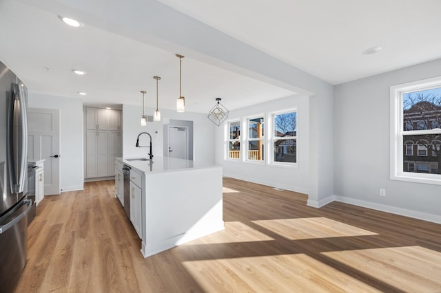1903 Thomas Ave N, Minneapolis, MN 55411 - kitchen with light wood-style floors, baseboards, stainless steel appliances, and a sink