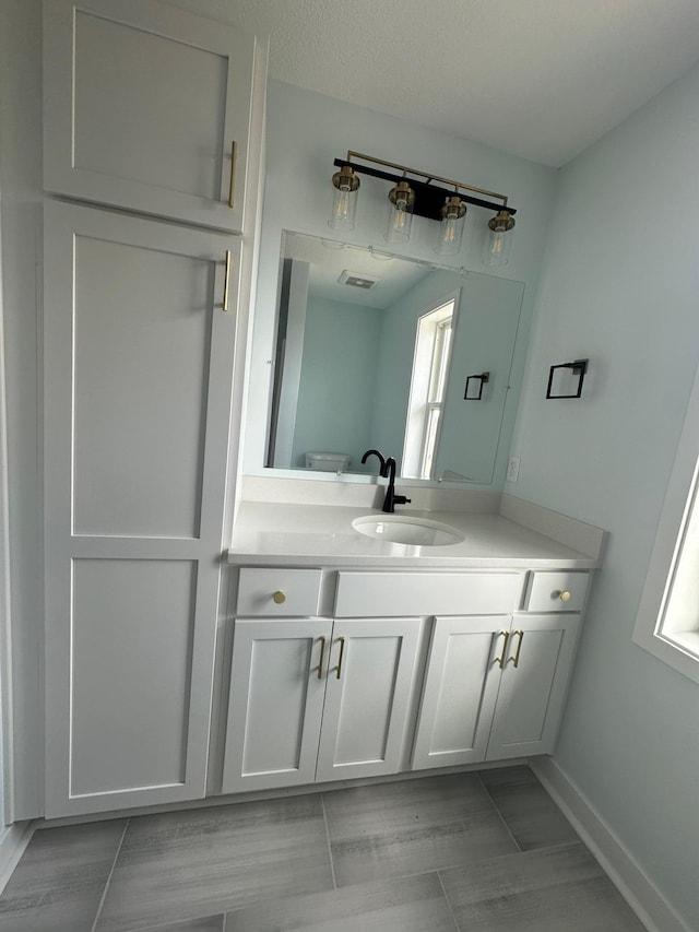 1903 Thomas Ave N, Minneapolis, MN 55411 - bathroom with baseboards, visible vents, and vanity