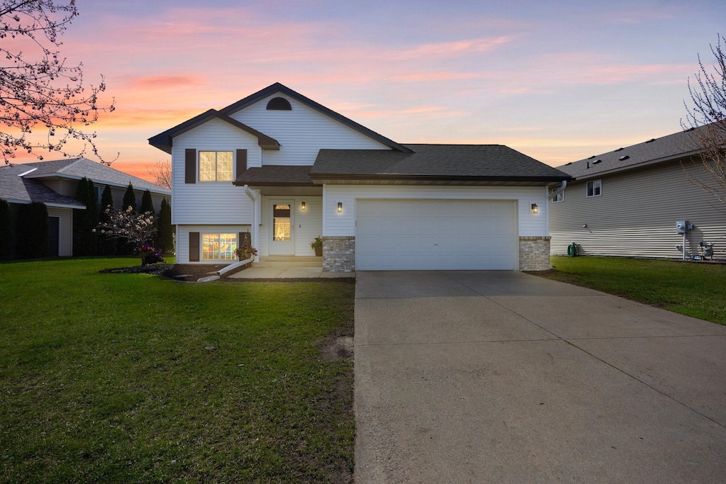 735 Harrison Dr, Big Lake, MN 55309 - tri-level home featuring a garage, a yard, a shingled roof, and concrete driveway